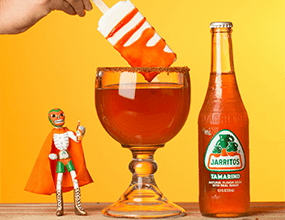 Jarritos soda with a mexican wrestler toy and large glass