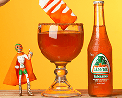 Jarritos soda with a mexican wrestler toy and large glass